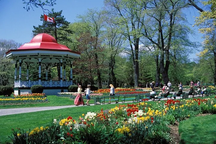 Personnes se détendant près du kiosque à musique au toit rouge dans les Jardins publics d'Halifax