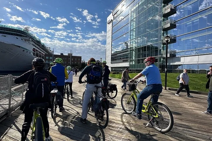 Cyclistes roulant sur une promenade à côté d'un grand navire de croisière.